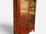 une image d'une armoire en bois avec une porte en verre
