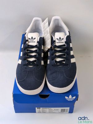 a pair of blue and white adidas sneakers on a blue box