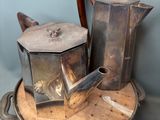 a silver tea pot sitting on top of a wooden tray