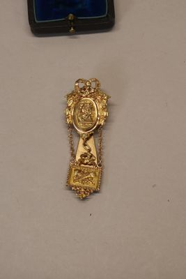 a gold cross on a table next to a blue box