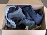 a cardboard box full of clothes sitting on the floor