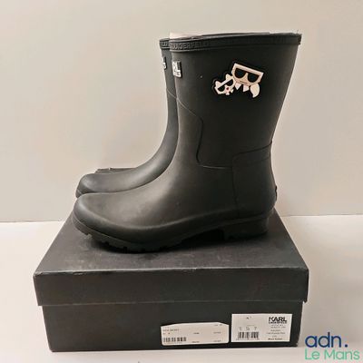 une paire de bottes de pluie noires posée sur une boîte