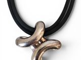 silver and black leather necklace with a silver and black pendant on a black cord