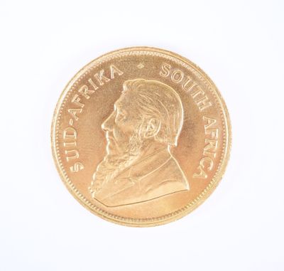 gros plan d'une pièce d'or sur une surface blanche