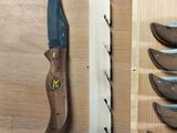 five knives and a knife holder on a wooden table