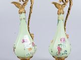 une paire de vases anciens ornés de motifs floraux, posés sur une table