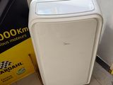 a small white air conditioner sitting next to a sign