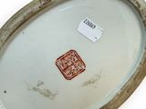 a white plate with a brown border and a red stamp on it