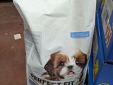 un sac de croquettes posé sur une pile de cartons