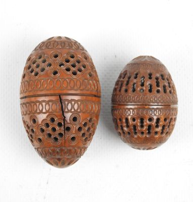 pair of carved wooden eggs with holes and holes in them