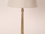 une lampe de table en laiton avec un abat-jour blanc sur fond blanc