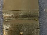 a close up of a black leather wallet on a blue surface