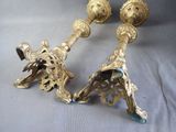 pair of ornate brass candlesticks on a grey background