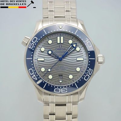 une montre en argent avec une lunette bleue