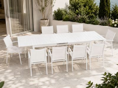 a white table and chairs on a patio by the water