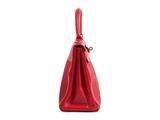the red purse is sitting on a white surface