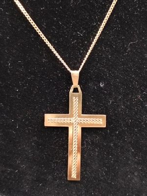 une croix en or sur un fond noir, avec une chaîne en or
