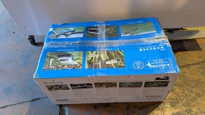 une pile de cartons posée par terre devant un réfrigérateur