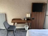 a desk with a chair and a television in a room