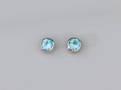 une paire de boucles d'oreilles en topaze bleue sur fond blanc