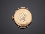 an antique gold pocket watch with a monogram on the dial