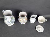 three small vases and a small bowl on a table