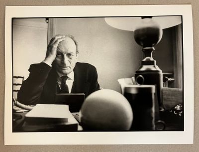 une photo en noir et blanc d'un homme assis à un bureau