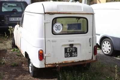 a small white van that is parked in the grass