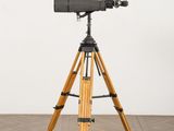 an image of a tripod on a wooden floor with a white wall in the background