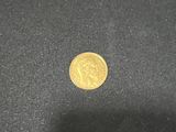 a close up of a gold coin on a black surface