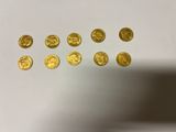 a close up of a bunch of gold coins on a white surface