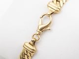 a close up of a gold bracelet on a white napkin