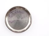 a close up of a small metal object with writing on it