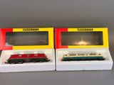two toy trains sitting in a box on a table