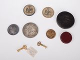 a lot of coins and a key on a white surface