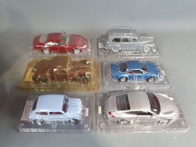 several toy cars are sitting in plastic boxes on a table