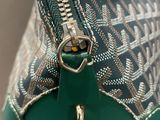 someone is holding a green purse with a zipper on top of it