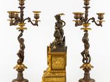 three antique bronze candlesticks with a statue of a man on a throne