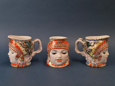 trois tasses en céramique ornées de motifs différents sur un fond bleu