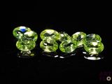 un groupe de perles en cristal vert posées sur une surface noire