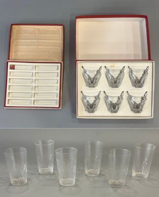 six verres et une boîte de verres vides posés sur une table