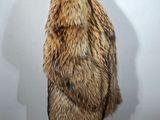 a woman in a fur coat stands against a white background