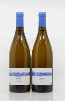 two bottles of white wine sitting next to each other on a white surface