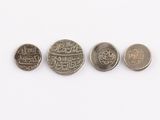 four different types of coins sitting on top of a white surface
