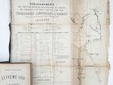 an old map and a book on a table with a white background
