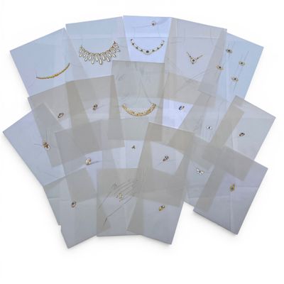 a bunch of white envelopes with gold and silver designs on them