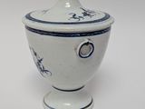 a white and blue bowl with a lid on a white table