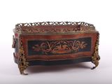 une boîte noire et rouge ornée de motifs dorés