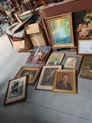 beaucoup de photos encadrées par terre dans un magasin