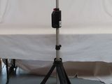 a camera on a tripod next to a white backdrop